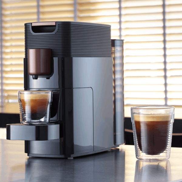 KFEE One pod coffee machine pouring a drink in a home setting