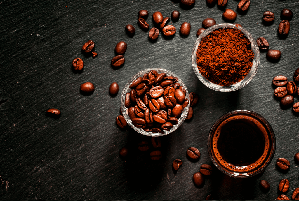 Ground coffee and whole beans on slate background